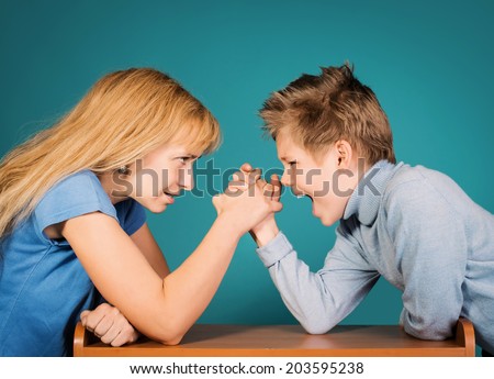 Son confronts his mother. Family, parents and children conflict concept. Woman and boy arm wrestling shouting on each other.