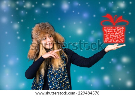 Happy surprised woman showing pointing on box with discounts 50%, 30%, 20%. Winter sale concept.