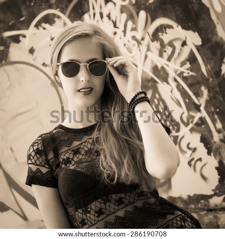 Perfect fashionable young lady wearing sunglasses. Black and white fashion model girl portrait with long hair. Glamour beautiful woman with healthy and beauty hair.