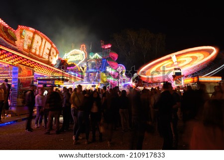Kreuzlingen, Switzerland - August 9, 2014: people at an event with roller coasters, flat rides and carousels called \