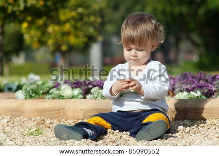 Little boy sits and plays in the park