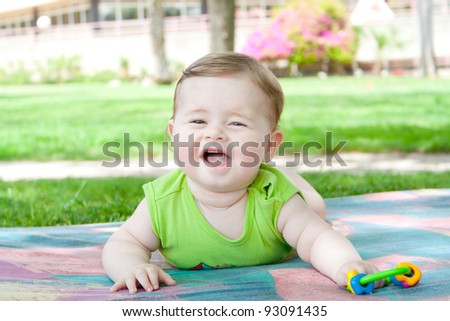 Smiling baby lying and played in the park