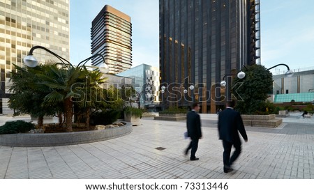 Business Center in Madrid, Spain with two businessmen men walking (motion blur)