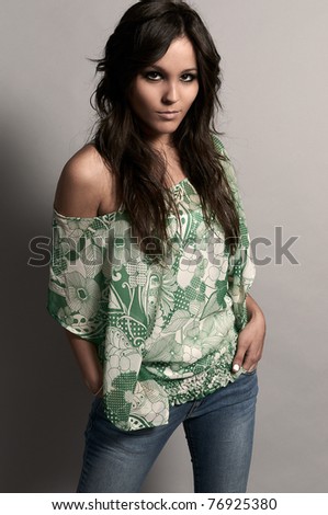 Fashion studio shot of beautiful woman with jeans and green blouse