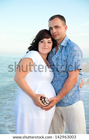 Pregnancy. Young loving couple on the beach. Happy family.