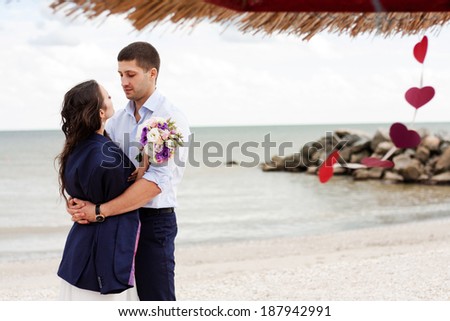 Happy newlyweds on the beach. Loving bride and groom near the sea.