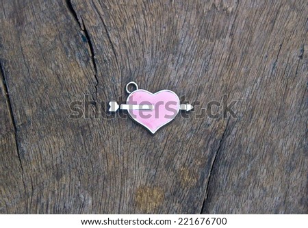 Vintage valentines day background. Heart with cupid arrow on wood background