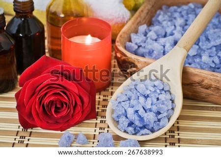 Composition with sea salt, stones, towel, infusion of herbs, candles and flower