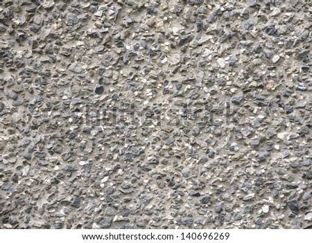 The concrete wall issued by small decorative pebbles