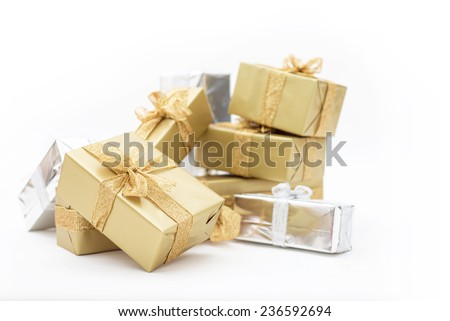 Beautiful gifts in gold and silver packaging for Christmas, holidays, isolated on white background. Sparkling ribbon with glitter on presents