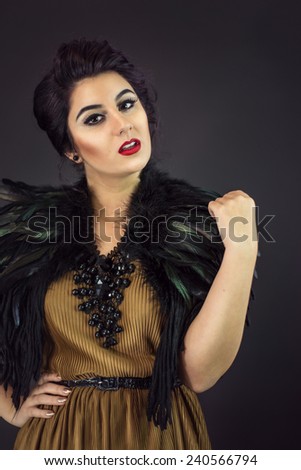 Portrait of Happy fashion woman dressed in a gold dress and feathers collar. New Year\'s Eve Party. Statement Necklace