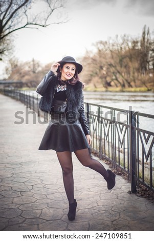 Stylish fashion Woman in trendy black leather and fur clothes. Turtle neck blouse and fedora hat