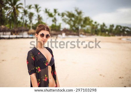 Sexy woman at the beach wearing swim top and cover up
