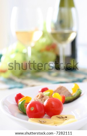 Healthy colorful vegetable platter with assorted vegetables, cheeses and wine