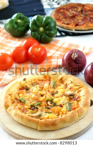 All vegetarian pizza on a circular wooden board on white tabletop