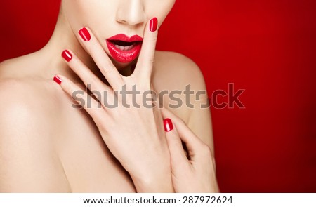 Woman face with red lips and red manicured nails. isolated on red background