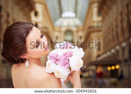 Bride standing in front of beautiful gallery. Bridal make up and hairstyle. Elegance.