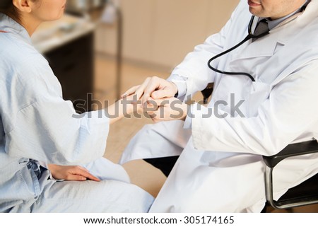 Medical doctor holding hand of the patient. Communication and service in the hospital.