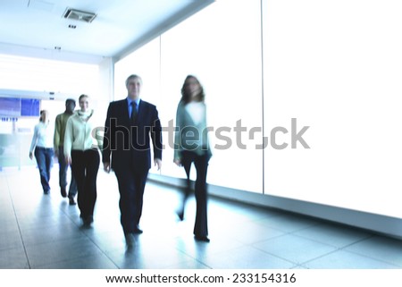 Smiling People walk in the corridor of a modern company looking forward