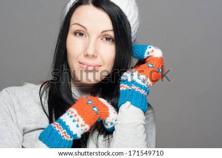 Winter Beauty Woman. Fashion Girl Concept. Skin and hair care in cold season. Beautiful woman with long hair wearing a sweater, scarf, hat and gloves. Holiday Fashion Portrait.