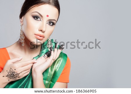 Beautiful young indian woman in traditional clothing with make-up and jewelry. Close-up portrait of a brunette traditionally dressed in sari. Bollywood dancer girl from India. Arabian bellydancer