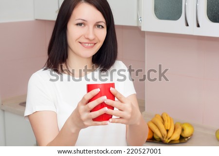 Young woman drinking coffee in the kitchen. Morning drink concept.