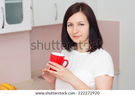 Young woman drinking coffee in the kitchen. Morning drink concept.