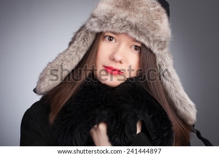 Winter Beauty Woman. Fashion Girl Concept. Skin and hair care in cold season. Portrait of a young girl with scarf, gloves and sweater.