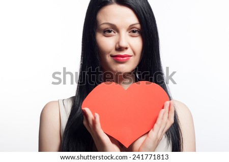 Valentine Day concept. Beautiful young smiling woman with a gift in the form of heart in her hands. Closeup fashion portrait.