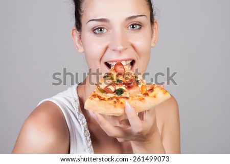 Beautiful close-up portrait of young woman eating pizza. Healthy and junk food concept. Skin care and beauty. Diet.