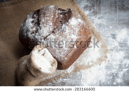retro bread in rustic style background.Fresh traditional bread on wooden ground with flour in a sack.
