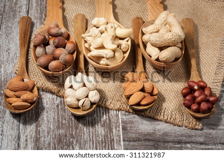 Healthy mix nuts on wooden background. Almonds, hazelnuts, cashews, peanuts