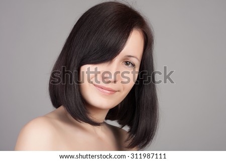 Close-up portrait of young beautiful woman with short hairstyle. Beautiful haircut. Short straight healthy hair.