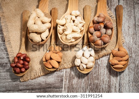 Healthy mix nuts on wooden background. Almonds, hazelnuts, cashews, peanuts
