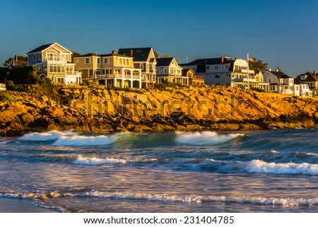 Waves in the Atlantic Ocean and houses on cliffs in York, Maine.