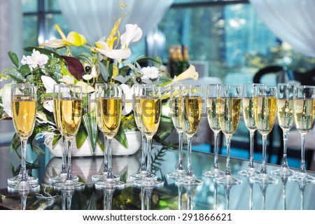 Elegant glasses with champagne standing in a row on table during party