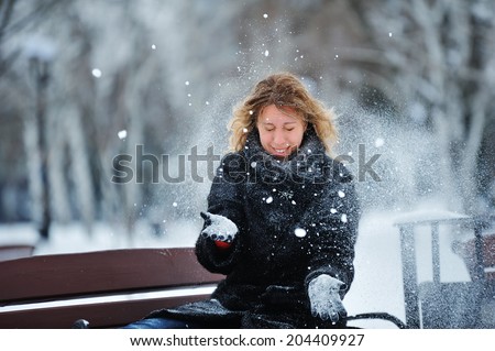 Girl throws snow into the air and on the face