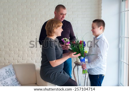 Little boy giving flowers to his mom on mother\'s day