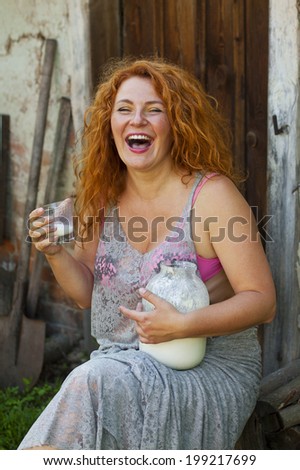 cheerful adult woman lead healthy lifestyle drinking milk in the village outside