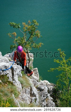 Woman adjusts climbing gear preparing climbing