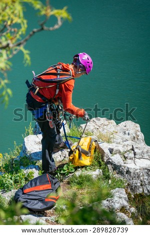 Woman adjusts climbing gear preparing climbing