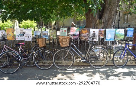 CAMBRIDGE, CAMBRIDGESHIRE, ENGLAND - JUNE 30, 2015: Bicycles and posters attached to railings