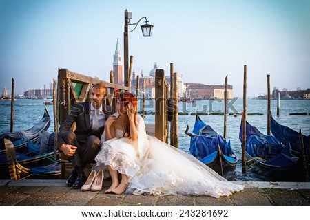VENICE, ITALY - FEBRUARY 27, 2014: Unidentified person, wedding couple sitting on a pier in Venice, Italy on February 2014.