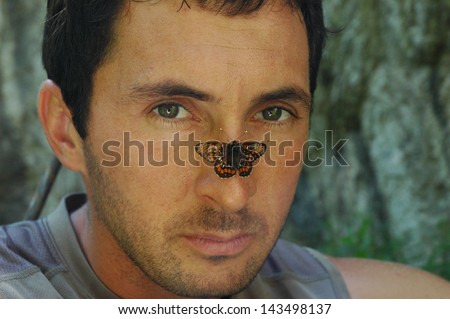 Man face portrait with butterfly on nose