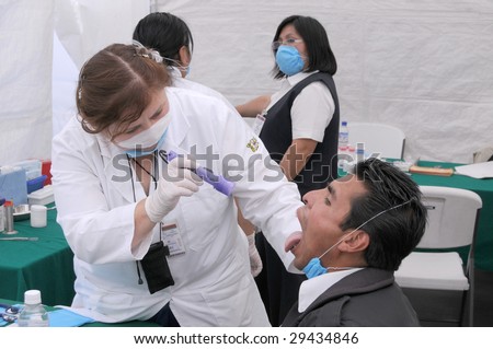 MEXICO CITY - APRIL 29: A doctor examines a flu patient for signs of Swine Flu at a clinic on April 29, 2009 in Mexico City. Reports of approximately 148 cases exist in about nine countries to-date.