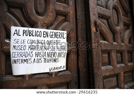 Closeup of a notice on an old wooden door saying that the museum in Mexico City will remain closed for the time being, as part of government measures to contain H1N1 swine flu influenza epidemic.
