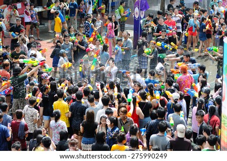 BANGKOK - APRIL 13: Unidentified people celebrate Songkran Day with water fights on April 13, 2015 at Siam Square in Bangkok. Pouring or spraying water to people on Songkran is a Thai tradition.