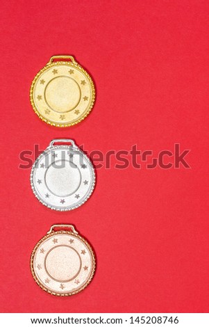 Medal Winners - A set of gold, silver and bronze medals on a red background. This can be used as a background to display (horizontally & vertically) competition winners.