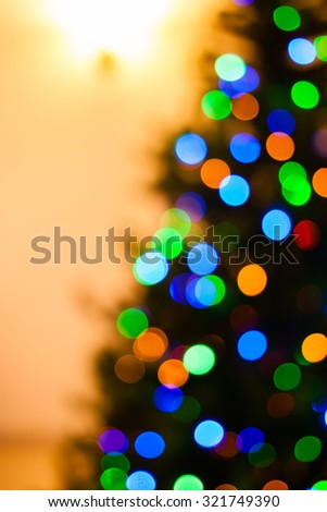 Colorful Christmas tree lights bokeh - A bright multicolor bokeh created by a set of de-focused lights on one half of a Christmas tree.