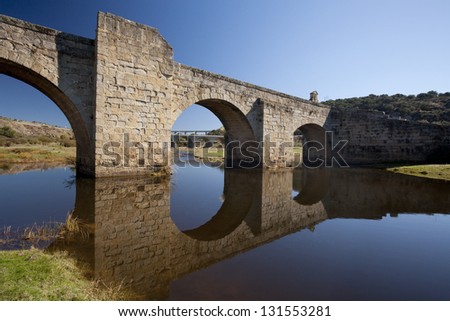 Bridge reflected in water Old bridge over  river in Spain, and two new ones at bottom